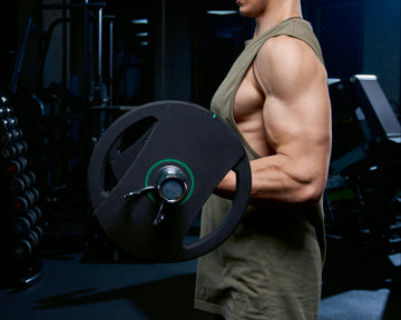 Muscular person holding a weight plate in a gym setting