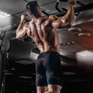 Muscular man flexing his arm in a gym setting